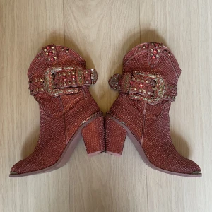 Glittriga cowboyboots  - Storlek us 8, sitter som en 38, jag har 39 och kommer i dom men dom känns ganska tajta då. Har bara använt ett fåtal gånger.