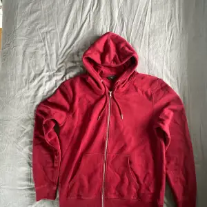 Säljer nu en röd zip hoodie! Är en hoodie som har kommit till användning ibland men inte så mycket då den känns lite för stor för en! Är i storlek L men skulle nog passa lika bra i XL. Köpte den för 1 år sen ungefär och har varit använd lite mellanåt! 