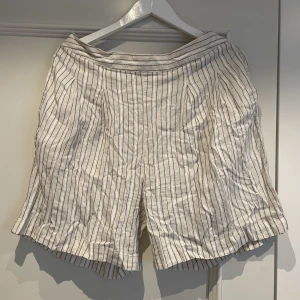 Shorts  - Ett par vita shorts med svarta ränder. Den är köpt från ICHI och är i storleken 42.  Säljer de för 20 kr + frakt