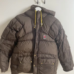Fjällräven jacka - Säljer min bruna vinterjacka från fjällräven.  Xs-s i storleken.  Den har ett litet hål på ena armen, bild kan fås om de är intressant, därav har jag sänkt priset. De går lätt att åtgärda. 