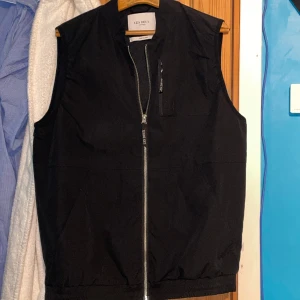 Les deux väst - Svart väst från populära märket Les Deux, västen är sparsamt använd och i supergott skick. Kan mötas i Västerås eller fraktas mot att köparen står för fraktkostnaden