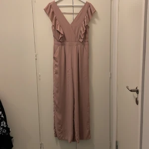 Byxdress - Byxdress från Bikbok. Välanvänd där några trådar på benen dragit ihop sig men annars i fint skick. Urringad med öppen rygg 