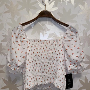 Offshoulder top NA-KD - Top från NA-KD med pösigare ärmar. Snygg att ha off shoulders. Aldrig använd med prislapp kvar. 