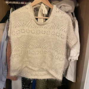 Stickad tröja  - En så fin stickad tröja som är kortarmad. Har en rosett där bak😍😍