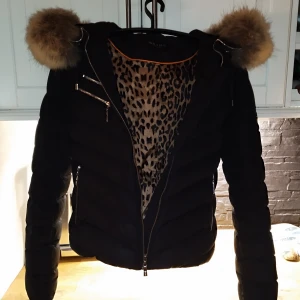 Hollies - Dunjacka med päls och guldiga dragkedjor. Mycket fin och varm. Kemtvättad innan den hängdes undan. Tyvärr är strl lappen borttagen. 