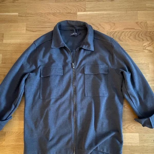 Overshirt - Grå overshirt från Dressman. Stilren kofta som ger en sofistikerad look. Strlk L men passar M 