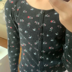 Tröja - Fin långärmad svart tröja med blommor. Har bara används några få gånger och är i bra skick.