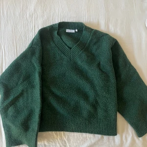 Grön tjocktröja - Supermysig tjocktröja från weekday! Den är en fantastisk grön färg och har en v-ringad hals. Har blivit lite nopprig men är annars i perfekt skick! 