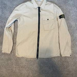 Säljer nu denna sjukt snygga stone island overshirten. Storlek L, beige. Vid frågor är det bara att höra av sig🤩