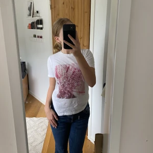 T-shirt - Vit t-shirt med ett rosa tryck, den har några fläckar men de tänker man knappt på, därav priset🫶🏼