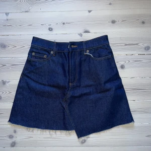 Jeanskjol other stories - Endast provad jeanskjol från & other stories Paris atelier. Asymmetrisk skärning och något utställd passform. Ekologisk bomull. Upphämtning vid Mariatorget alternativt skickas mot frakt.