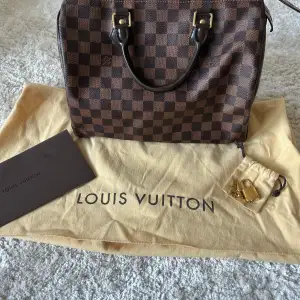 En väl omhändertagen Louis Vuitton Speedy damier 30 väska som ökar i pris varje år. Väskan är i fint skick, dock lite slitage på utsidan samt mindre fläck på insidan (skickar bilder vid intresse). Med väskan medföljer kvitto, dustbag, lås och nyckel. 