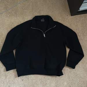 En svart halfzip hoodie som inte kommit till användning. Lite oversized 