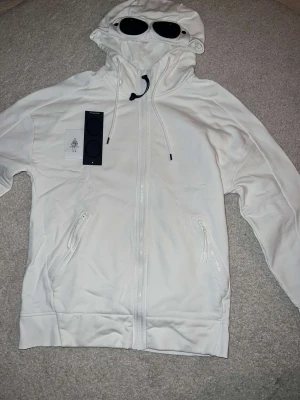 Cp company zip hoodie  - Säljer denna cp company zip up hoodien som e använd två gånger och tvättad två gånger. Den är 10/10 skick och färgen samma som ny. Klistermärket och extra knapparna får man med vid köp! Kan inte tänka mig sänka priset mer än detta!