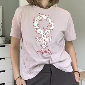 Rosa T-shirt med kvinnomärket  I gott skick men liten rosa fläck på framsidan