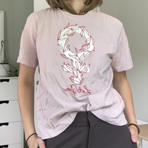 Monki T-shirt - Rosa T-shirt med kvinnomärket  I gott skick men liten rosa fläck på framsidan