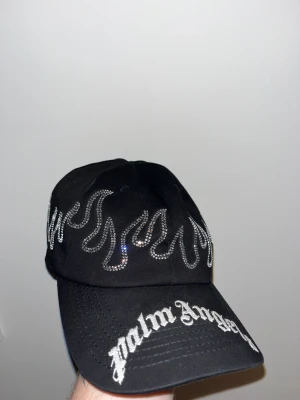 Palm Angels keps  - Säljer denna sjukt snygga Palm angels keps med rhinestones! Kepsen är endast använd några gånger och nypris ligger på ca 1500-1600.  Tveka inte att skriva vid eventuella frågor.