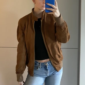 Vintage mockajacka - Vintage mockajacka i äkta läder med bomberjacka fit. Perfekt till hösten!  Köpt begagnad på Beyond Retro men den är absolut i bra skick.  Det står ej storlek, men oversized på mig som har i vanliga fall storlek S. Storlek ca M/L