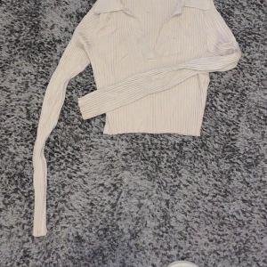 Topp - En ribbad biege croppad topp.