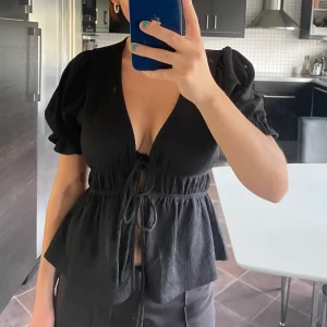 Topp  - En topp från Gina Tricot som inte kommit till användning. Det finns två snörningar som går att reglerar själv!