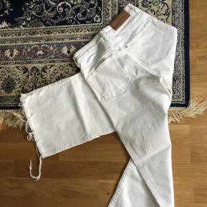 H&M Culotte jeans white - Vita culotte jeans från H&M. Storlek 25, highwaist. Jättefina på sommaren till klackar! OBS!! Gula fläckar från bruna skinnlappen på baksidan har färgats av på jeansen, se bild 3. Köpes i befintligt skick!! Fransade nertill. 