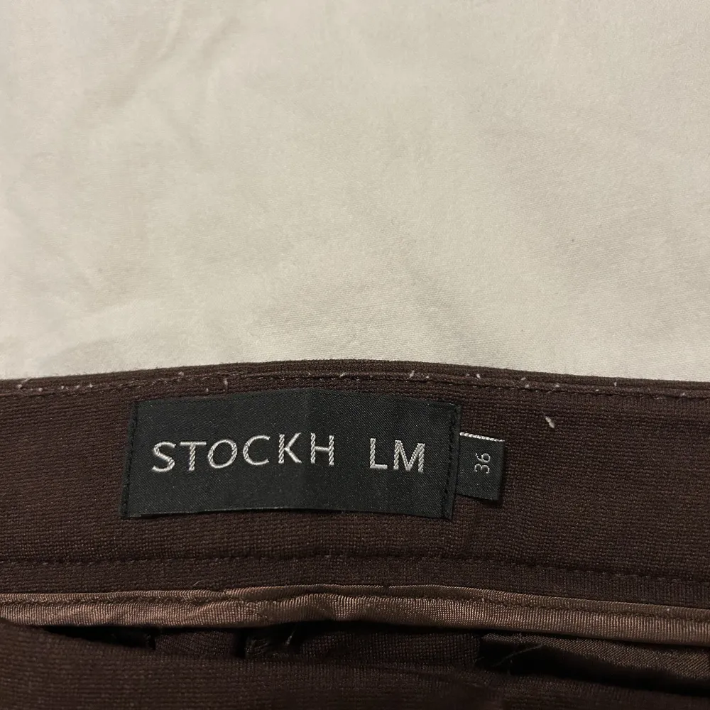 Ett par mörkbrunas kostymbyxor från stockh LM i strl 36. Passformen är ganska tight med smalare ben. (Använda ett fåtal gånger) Nypris: 700. Farkut & Housut.