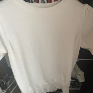 Vit tröja  - Vit tröja som sitter lite tajt. Den är lite nopprig men inget som syns jätte mycket. 