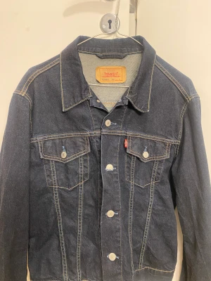 Vintage Levis jeansjacka - Säljer en oanvänd vintage Levi’s jeansjacka på grund av att jag har en liknande. Jackans originalpris var 1200kr, men säljer nu för endast 450kr. På taggen står det att jackan är i storleken L, men skulle säga att den är mer utav en M eller en oversize S.