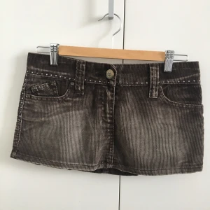 Brun minikjol från River Island - Brun minikjol i manchester från River Island, sjukt cool! Med rhinestonedetaljer som alla sitter kvar. Min systers gamla och bara använd ngn enstaka gång tror jag. Mått: midja 39 cm, längd 27 cm.