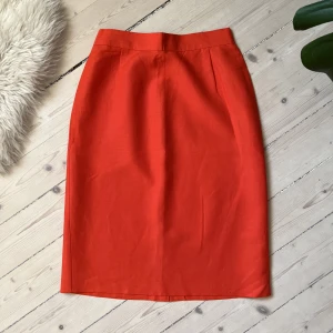 Kjol i Linnemix - Nätt röd pennkjol i linnemix med slits och dragkedja. Bara att skriva om ni vill ha exakta mått :) 