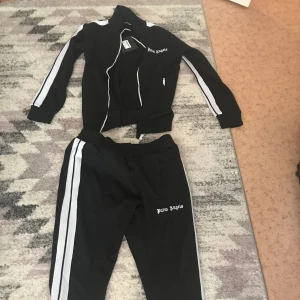 Palm angels dress - En äkta palm angels dress , koftan är i storlek S och byxorna i M men koftan passar även i S, den är oandvänd och jag säljer den för att den är för stor för mig, står ej för frakten pma mig om ni vill ha mer info 🥰