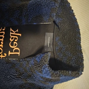 Fleecejacka  - Peak performance fleecejacka blå och svart med orange text, storlek L.   dragkedjan funkar utmärkt! 