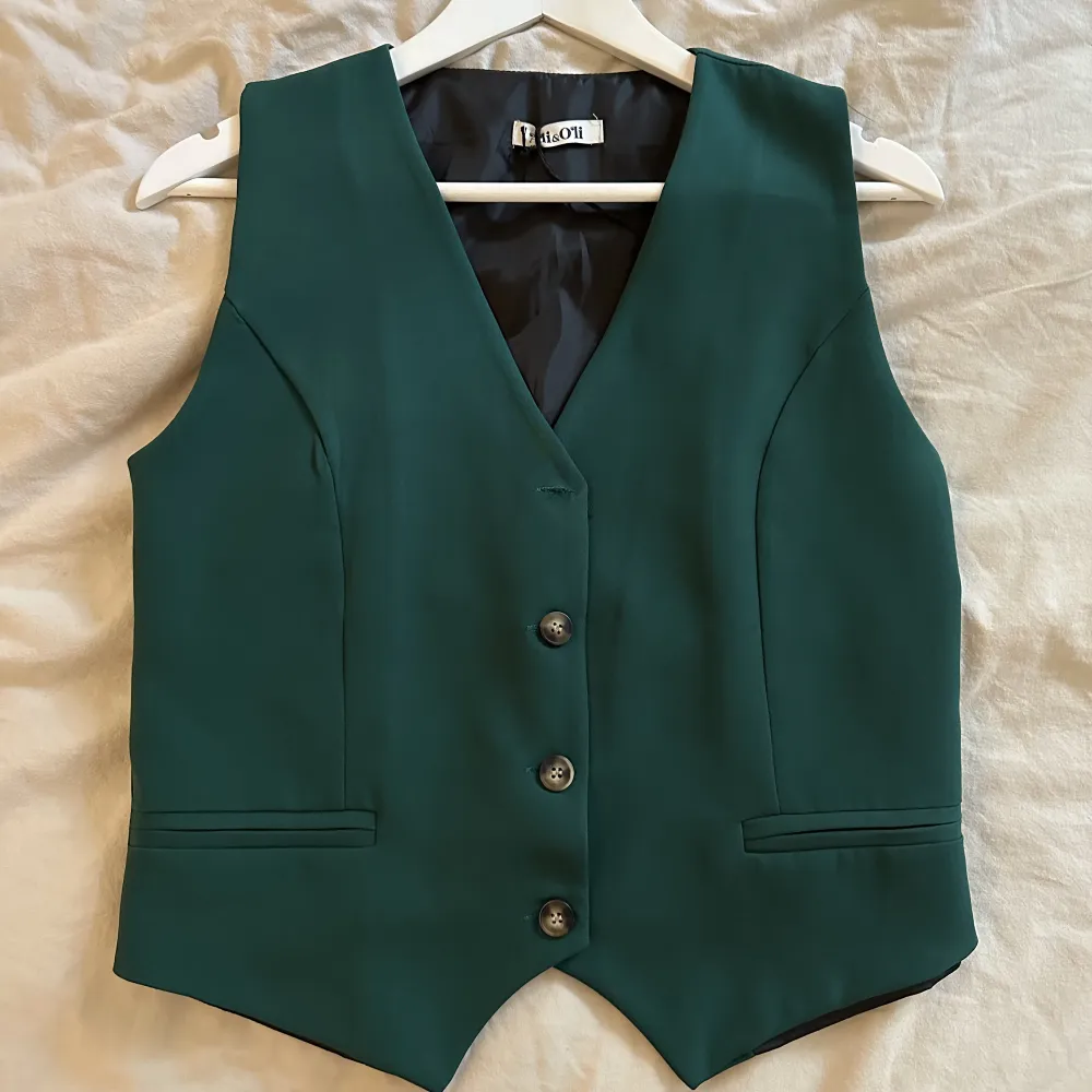 Grön kostymväst, köpt i Spanien. Helt oanvänd! Köparen står för frakten 💚. Toppar.