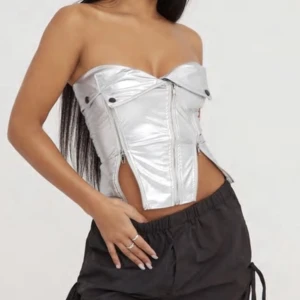 Silvrig biker korsett  - Säljer denna då jag har en exakt likadan fick alltså dubbelt av likadana plagg, sitter jätte fint på och blixtlåsen är justerbara. Köpt för 43 pund helt ny med prislapparna på aldrig använd.