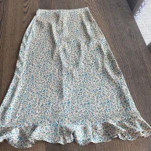 Långkjol - Hej, jag säljer min siden långkjol ifrån zara. Den är i ett blommigt mönster med små volanger där nere och knappar på ena sidan. Endast använda några fåtal gånger och därför i nyskick. Frakten står jag inte för!