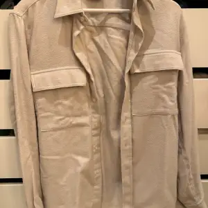 Säljer denna vita/beige overshirt från Oscar Jacobson. Helt oanvändvänd så skicket är 10/10. Storlek S men sitter som M. Perfekt till hösten. 