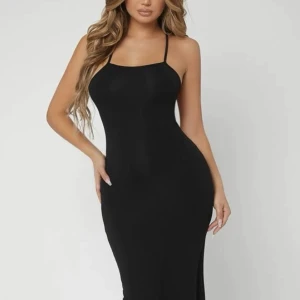 Svart lång klänning med detalj på ryggen  - Svart lång klänning med snören på ryggen, jätte skönt material. Oanvänd 