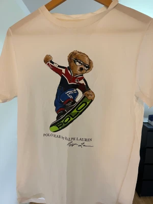 Ralph lauren t-shirt - Ralph lauren t-shirt med en Björn på! Tröjan har använts max 10 gånger så därför är skicket prima (9/10)!😀 Tröjan passar personen med xs perfekt! Nypris: 529kr