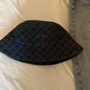 yves saint laurent buckethat i jeans material. Tecken på användning finns såsom att den är lite solblekt.