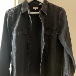 Svart/grå jeansskjorta från Levi's - Supersnygg skjorta från Levi's. Aldrig använt den men ägt den i typ 3 år. Sitter perfekt på mig som är 167cm, men passar både längre och kortare personer. Köpte den för 600kr. 