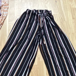 Luftiga byxor  - Säljer luftiga byxor som  är svarat, rosa/orange och vita. 