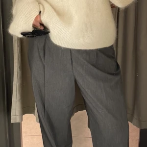 Gråa kostymbyxor UNIQLO - Säljer trendiga gråa kostymbyxor köpta på Uniqlo, pga lite för stora för mig. Använda 2-3 gånger.   Står ingen storlek på lappen, men skulle säga att de är stl 40/L  Nypris 499kr