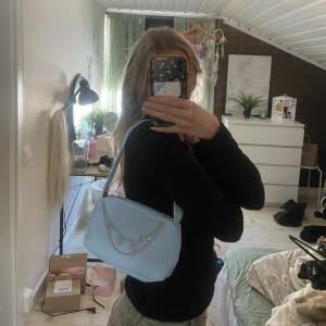 Blå axelväska - Jättesöt blå axelväska från shein med kedjor som detaljer. Kommer aldrig till användning därför säljer jag den.