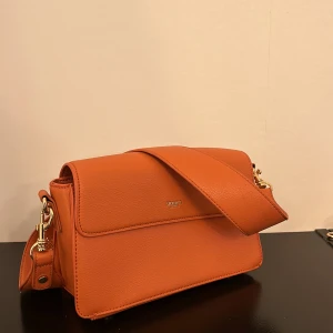 Väska    - Säljer en helt oanvänd väska, säljs med både axelband samt ett band så att man kan ha väskan crossbody. 