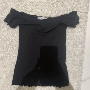 Topp - En svart topp, offshoulder.  Storlek XS. 
