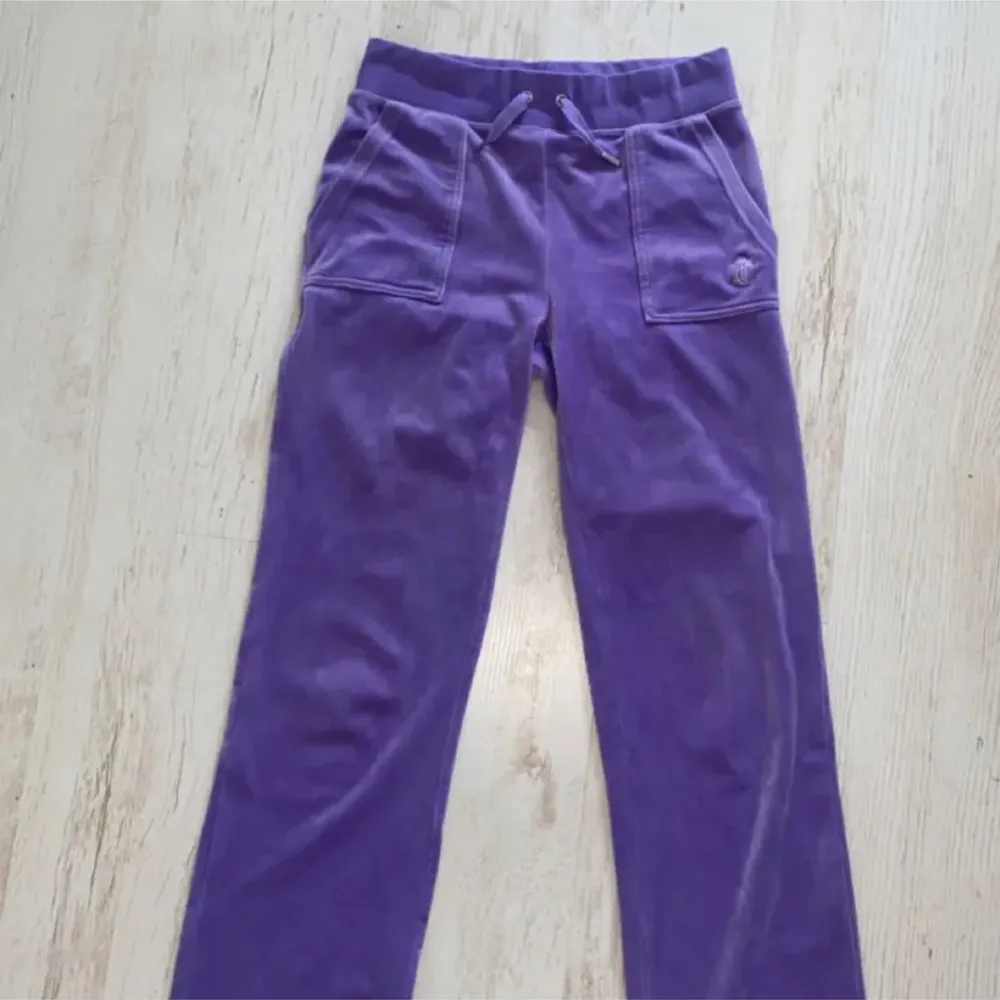 Juicy couture byxor i färgen violet tulip. Bra skick å sparsamt använda, metallbiten på ena snöret har dessvärre farit bort men inget som man tänker på. Nypris 1200 kr. Betalningen sker endast via plickappen för köparens säkerhet!🥰. Jeans & Byxor.