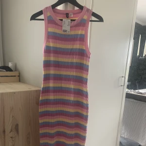 Stickad klänning  - En finstrimlad klänning som går till vaderna. Storleken är XL men skulle mer säga att den är som en L. Oanvänd.