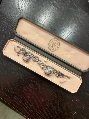 Juciy couture armband  - Charm armband från juicy Couture med två charms i orginaltrogen box. I gott skick. 
