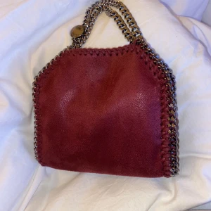 stella mccartney väska  - intressekoll på min stella mccartney falabella tiny tote. Den är i den perfekta röda färgen. Väskan har dustbag och kort och även nummer i väskan. i 10/10 skick. kom gärna med bud! 