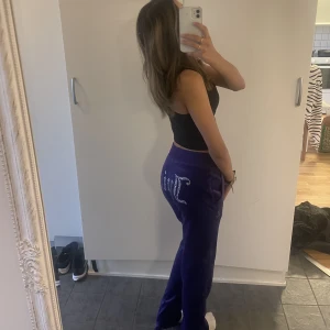 Fin fina lila Juicy Couture byxor! - Dom här fina byxorna är knappt använda och säljs för billigt pris då jag köpte dom för 800kr. Dom är fina till vardags men även till fest. Väldigt bekväma. Snygga glitter detaljer. Snören som går och knyta och även stretchiga, går och använda från XXS-M.